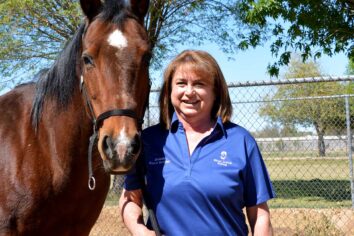 Melody standing next to a horse